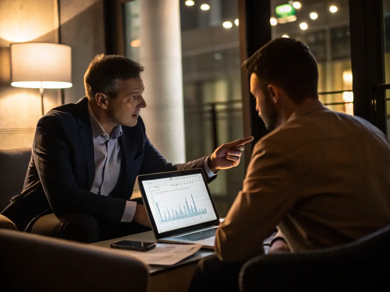 An image of a financial advisor discussing investment options with a client over a laptop, with charts and graphs in the background, representing Wealth Building Consultation.